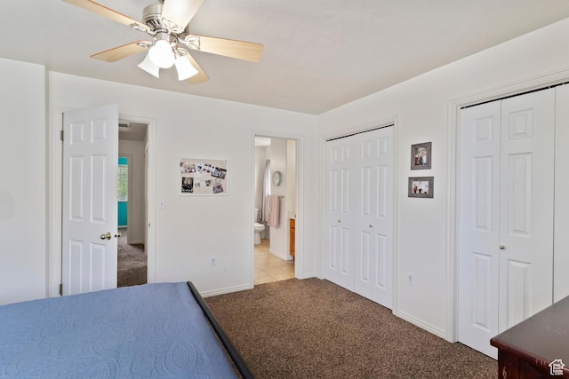 bedroom featuring carpet flooring, multiple closets, baseboards, ensuite bathroom, and a ceiling fan