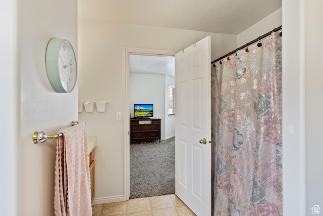 full bathroom with tile patterned flooring, vanity, curtained shower, and baseboards