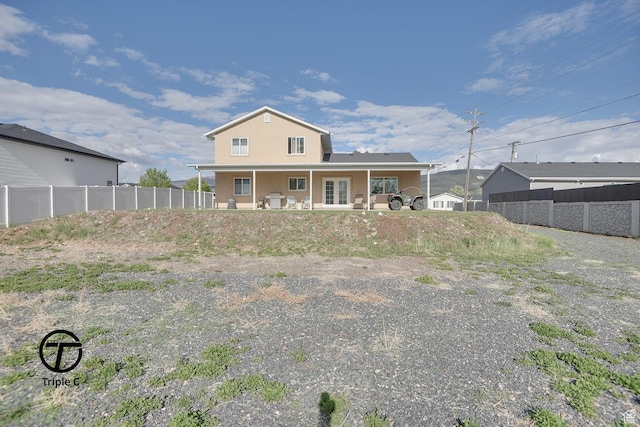 rear view of house featuring fence, stucco siding, french doors, and a patio area