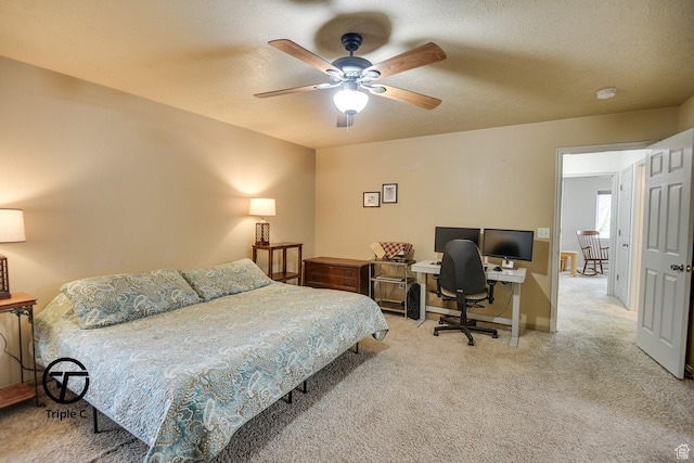 carpeted bedroom with a desk, baseboards, a textured ceiling, and a ceiling fan