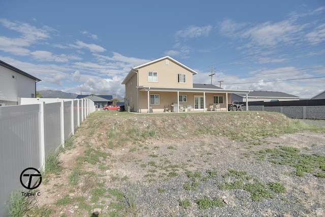 back of property with fence, a patio, french doors, and stucco siding