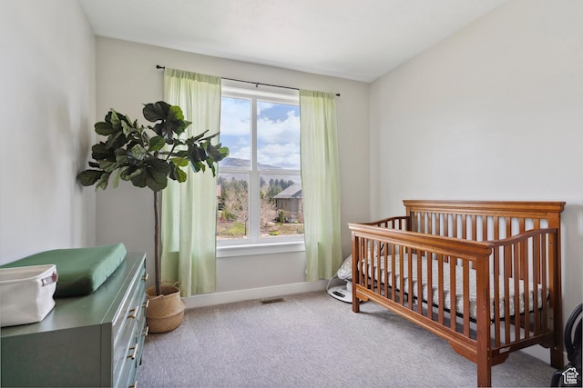 bedroom featuring carpet, baseboards, and a crib