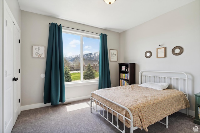 bedroom featuring carpet, multiple windows, and baseboards