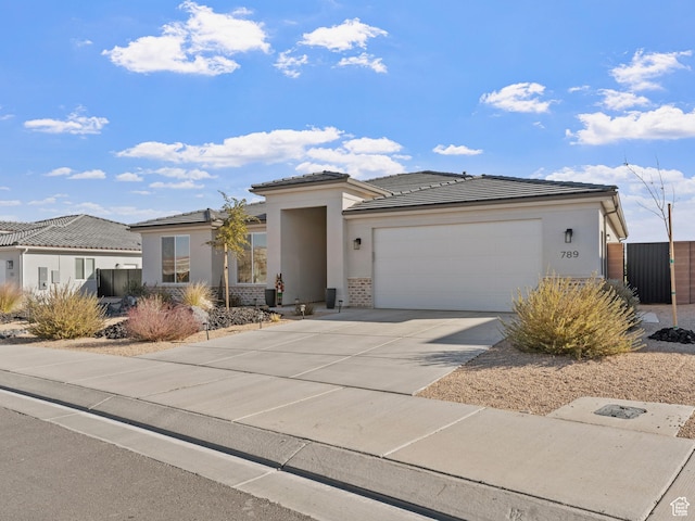 view of front facade featuring a garage, concrete driveway, stucco siding, and brick siding