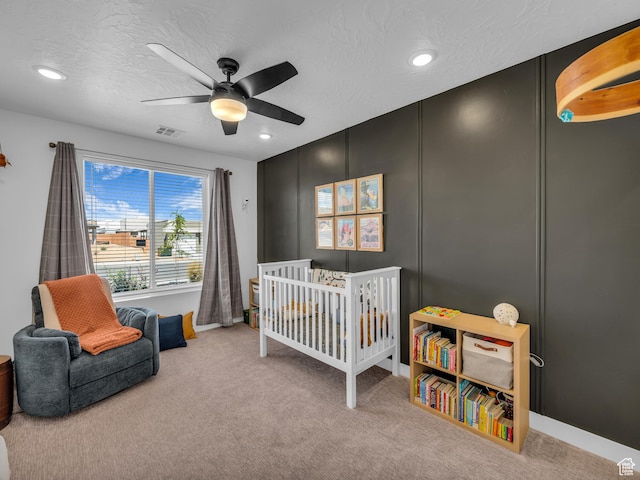 carpeted bedroom featuring recessed lighting, ceiling fan, baseboards, and a nursery area