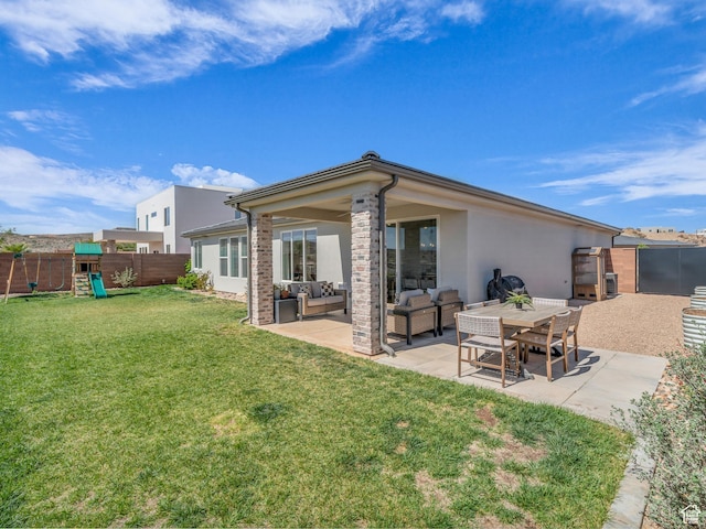 back of house with outdoor lounge area, a patio, a playground, and stucco siding