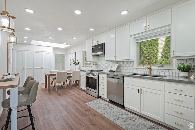 462 E 1700 S, Salt Lake City, UT 84115 - kitchen with a sink, stainless steel appliances, wood finished floors, decorative backsplash, and recessed lighting