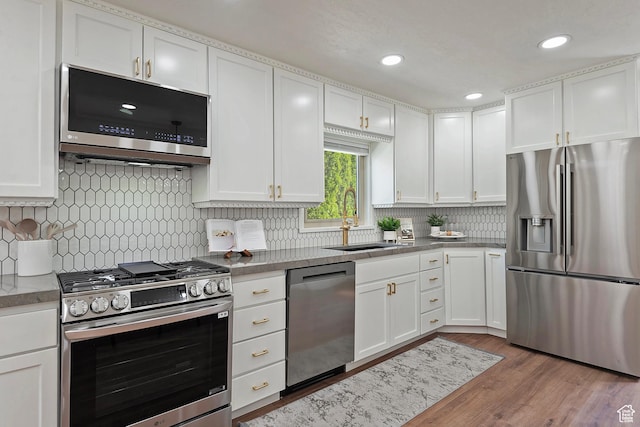 462 E 1700 S, Salt Lake City, UT 84115 - kitchen with appliances with stainless steel finishes, a sink, white cabinetry, wood finished floors, and recessed lighting