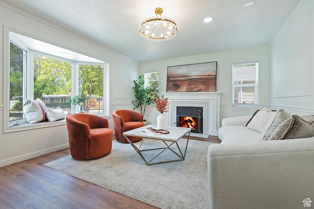 462 E 1700 S, Salt Lake City, UT 84115 - living room featuring a tiled fireplace, crown molding, plenty of natural light, wood finished floors, and a chandelier