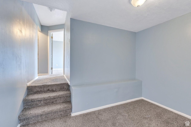 stairs featuring carpet and baseboards