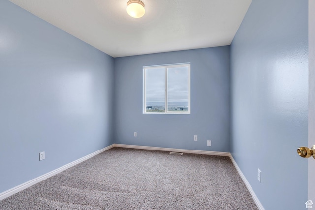carpeted empty room with baseboards