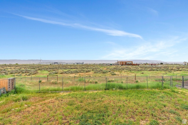 view of yard with fence, a rural view, and a mountain view