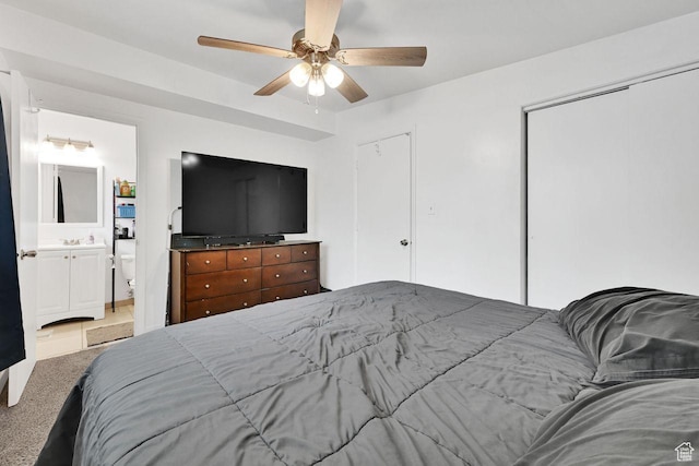 carpeted bedroom featuring ceiling fan and ensuite bath