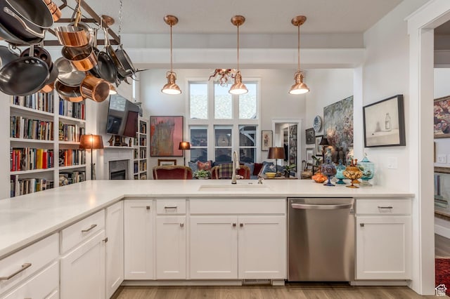 11243 S Prosperity Rd, South Jordan, UT 84009 - kitchen with stainless steel dishwasher, a fireplace, light countertops, light wood-style floors, and white cabinets