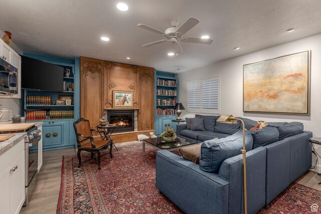 11243 S Prosperity Rd, South Jordan, UT 84009 - living room featuring light wood-type flooring, a large fireplace, a ceiling fan, and recessed lighting