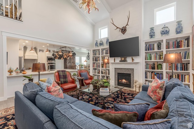 11243 S Prosperity Rd, South Jordan, UT 84009 - living area with high vaulted ceiling, a lit fireplace, wood finished floors, and a chandelier
