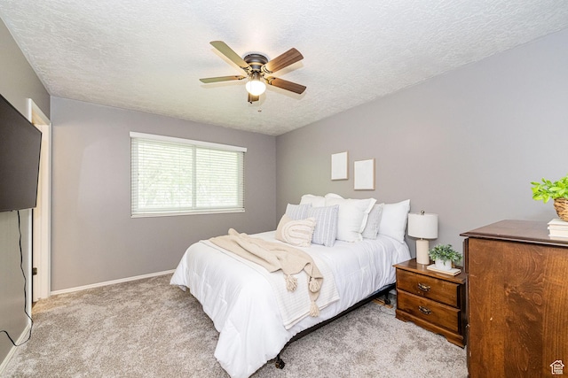 carpeted bedroom featuring a textured ceiling, baseboards, and ceiling fan