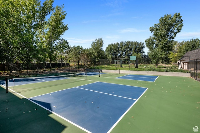view of tennis court featuring fence and community basketball court