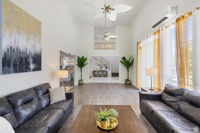 1890 W Rock Hollow Rd, Bluffdale, UT 84065 - living room with a wall mounted AC, stairs, ornamental molding, wood finished floors, and a high ceiling