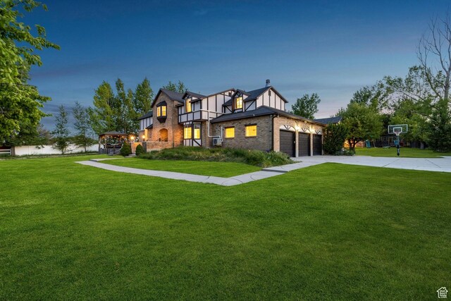 1890 W Rock Hollow Rd, Bluffdale, UT 84065 - tudor-style house with a front lawn, brick siding, an attached garage, and driveway