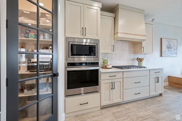 2883 S 3640 W, Hurricane, UT 84737 - kitchen with built in appliances, custom range hood, decorative backsplash, light countertops, and white cabinets