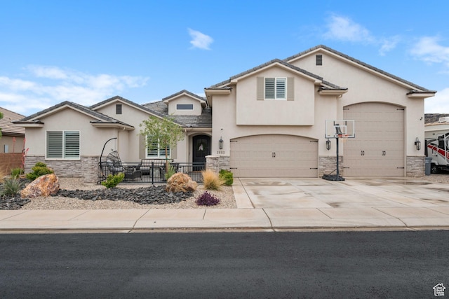 view of front of property featuring stone siding, stucco siding, driveway, a tile roof, and fence