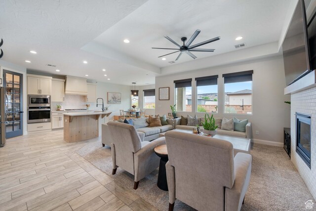 2883 S 3640 W, Hurricane, UT 84737 - living room with recessed lighting, a ceiling fan, a glass covered fireplace, baseboards, and a raised ceiling