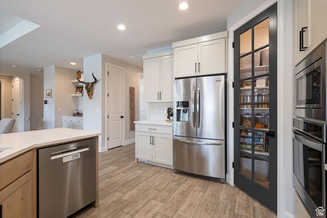2883 S 3640 W, Hurricane, UT 84737 - kitchen featuring appliances with stainless steel finishes, light countertops, light wood-style flooring, recessed lighting, and arched walkways