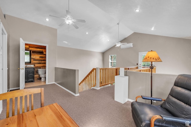 living area featuring an upstairs landing, a ceiling fan, a wall mounted air conditioner, lofted ceiling, and baseboards