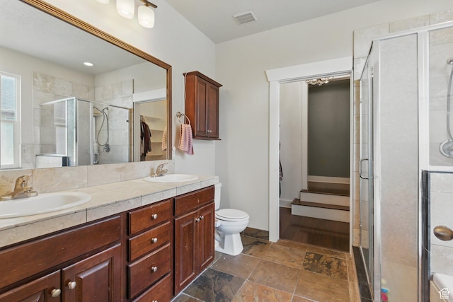 14349 S Round Rock Dr, Herriman, UT 84096 - bathroom with a shower stall, double vanity, stone finish floors, toilet, and baseboards