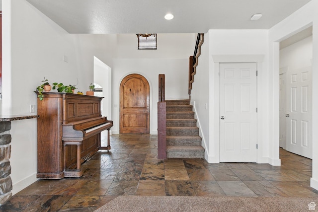 14349 S Round Rock Dr, Herriman, UT 84096 - entryway featuring stone tile flooring, baseboards, stairway, arched walkways, and recessed lighting