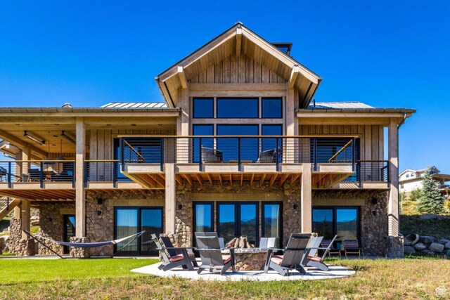7485 E Moon Light Dr, Heber City, UT 84032 - rear view of house featuring a balcony, stone siding, a standing seam roof, and a patio area