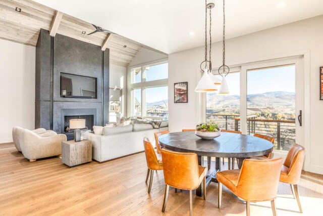 7485 E Moon Light Dr, Heber City, UT 84032 - dining space with light wood-type flooring, a fireplace, and vaulted ceiling