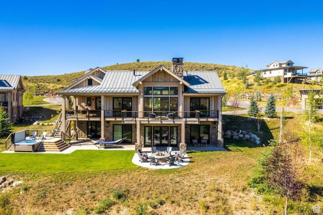 7485 E Moon Light Dr, Heber City, UT 84032 - back of house with a standing seam roof, a patio, a chimney, stairway, and metal roof