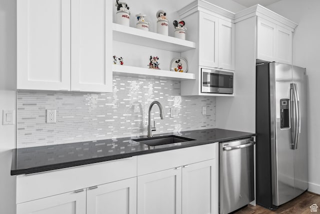 kitchen with stainless steel appliances, a sink, white cabinetry, open shelves, and decorative backsplash