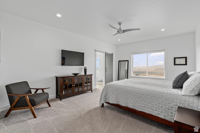 bedroom with a barn door, light carpet, recessed lighting, a ceiling fan, and baseboards