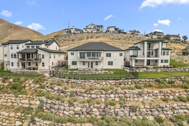back of house with a balcony, a mountain view, and a residential view