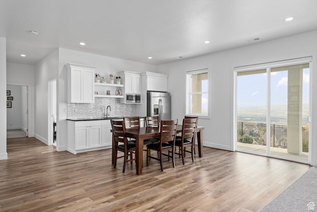 dining room featuring wood finished floors, baseboards, and recessed lighting