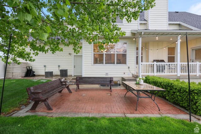 rear view of property featuring central air condition unit, a patio, and a chimney