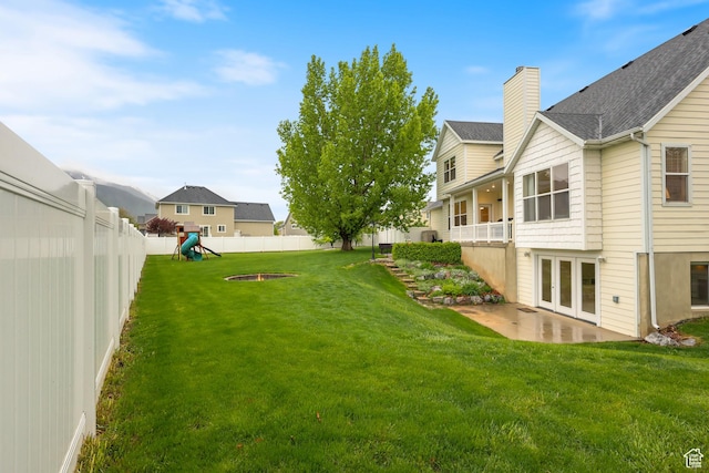 view of yard featuring a patio, a playground, french doors, and a residential view