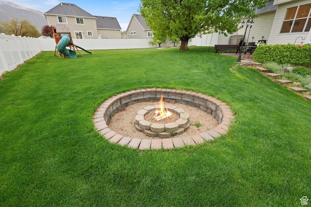 view of yard featuring a playground, an outdoor fire pit, and a patio