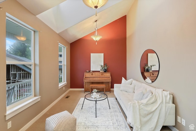 carpeted living room with healthy amount of natural light, baseboards, and lofted ceiling