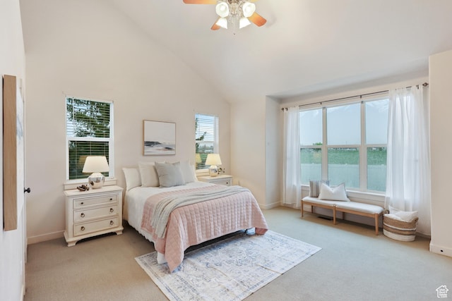bedroom with light carpet, baseboards, high vaulted ceiling, and a ceiling fan