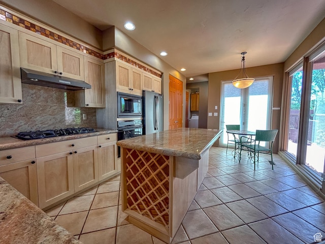 2255 N Tuweap Dr Unit 50, St George, UT 84770 - kitchen with under cabinet range hood, black appliances, washer / dryer, decorative backsplash, and plenty of natural light