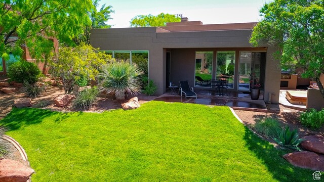 2255 N Tuweap Dr Unit 50, St George, UT 84770 - rear view of house featuring a patio, stucco siding, a lawn, and a chimney