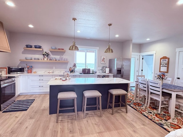 295 E 2nd N, Paris, ID 83261 - kitchen featuring stainless steel appliances, a center island, light wood-style floors, light stone counters, and recessed lighting