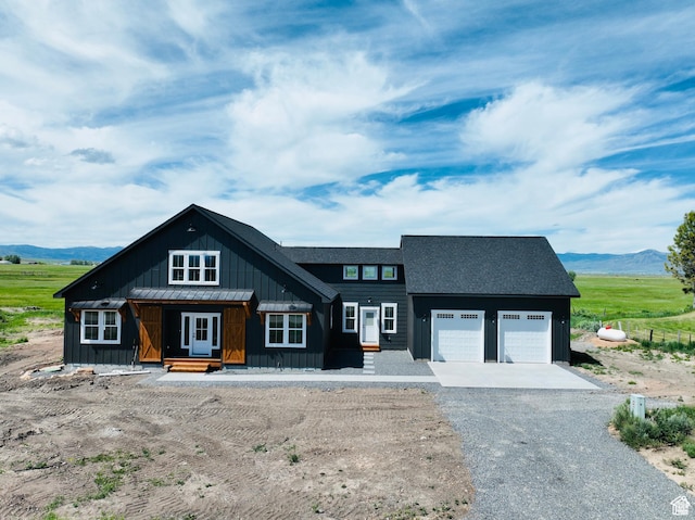 295 E 2nd N, Paris, ID 83261 - view of front of home with board and batten siding, an attached garage, gravel driveway, and a mountain view