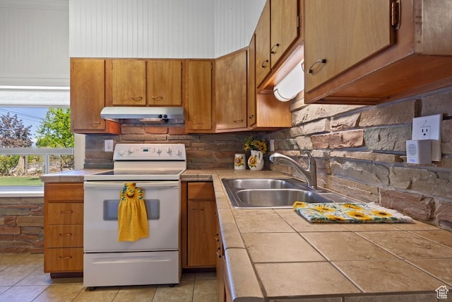 105 S 500 E, Salem, UT 84653 - kitchen featuring white range with electric cooktop, tile countertops, under cabinet range hood, a sink, and brown cabinets
