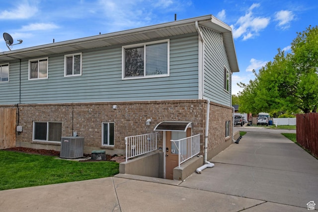 228 W 470 S, American Fork, UT 84003 - rear view of house with central air condition unit, fence, concrete driveway, and brick siding