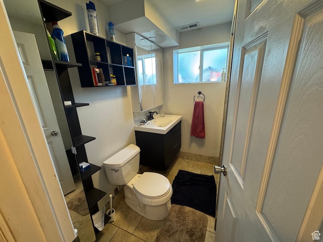 bathroom featuring toilet, tile patterned flooring, and vanity